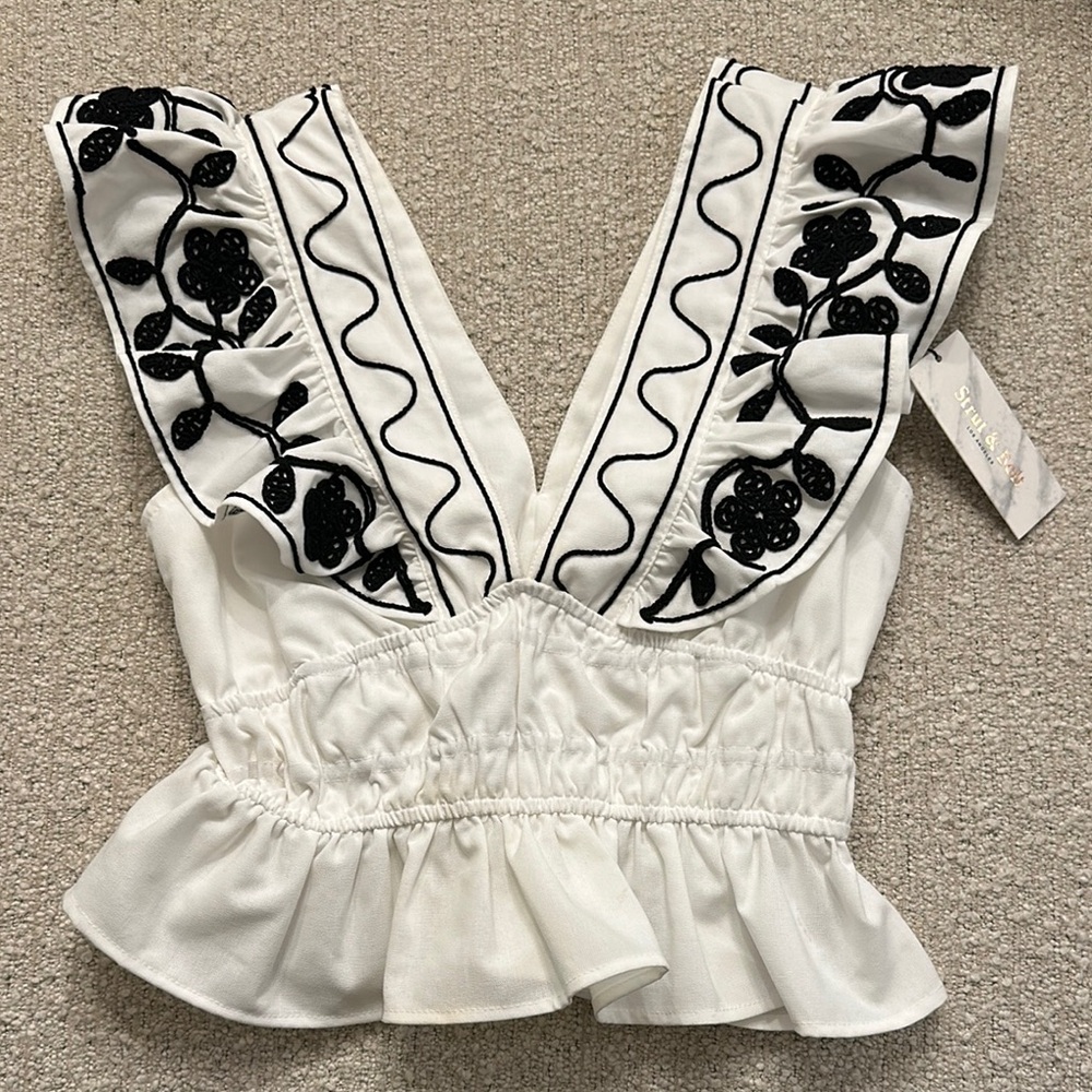 White V-neck Sleeveless Blouse with Ruffled Hem and Embellished Bib Collar